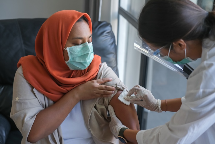 Nurse giving vaccine shot to patient