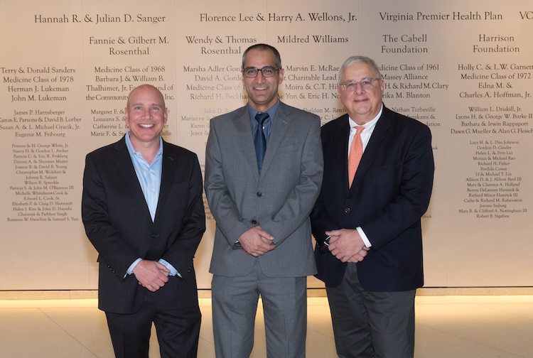 three men stand together for a photo in suits