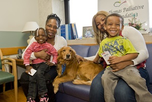 A family is pictured in a hosptial room with their dog