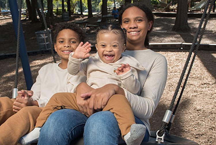 Three siblings together on a swing