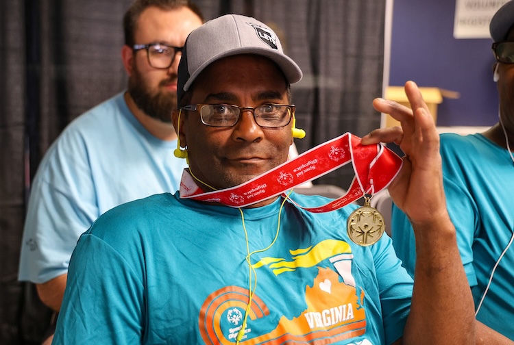 Man smiles with gold medal