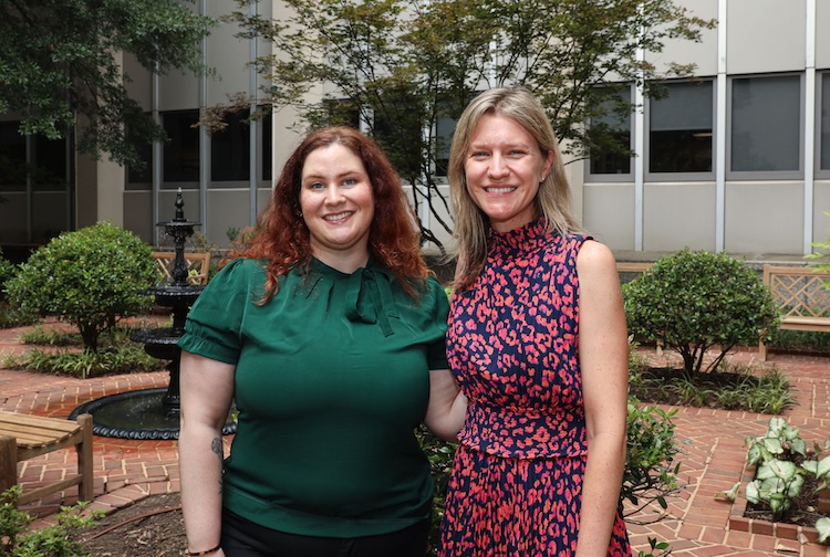 Two women standing next to each other outside a building