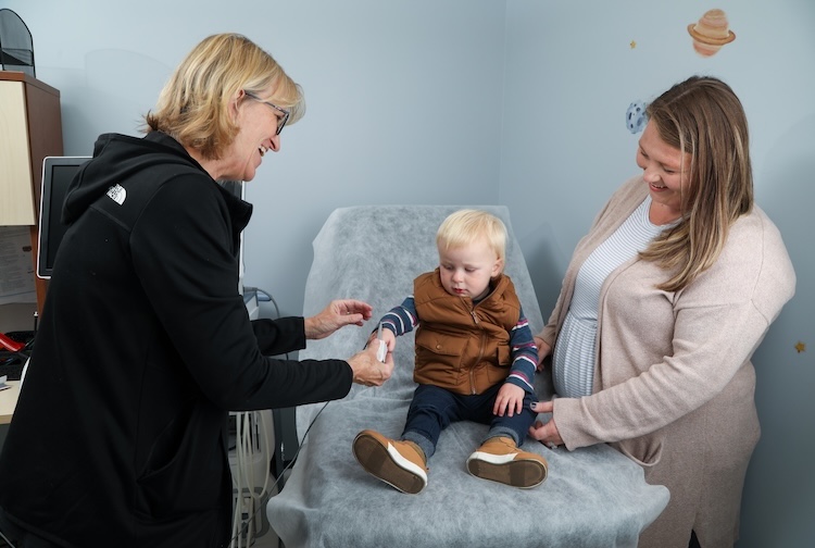 Nurse taking blood pressure reading of toddler