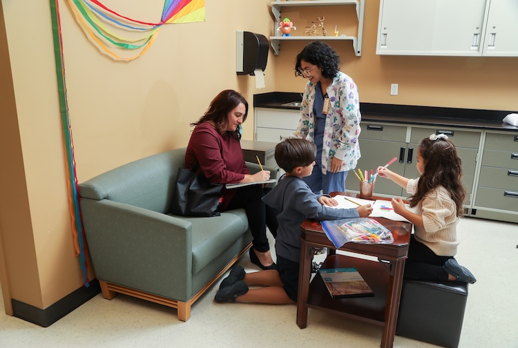 woman signing paperwork for a clinician-researcher while her play