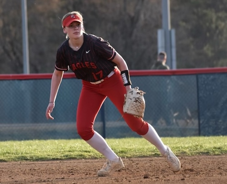 Softball player stands ready to catch the ball