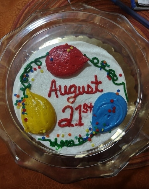 Cake with the date August 21 written in frosting.