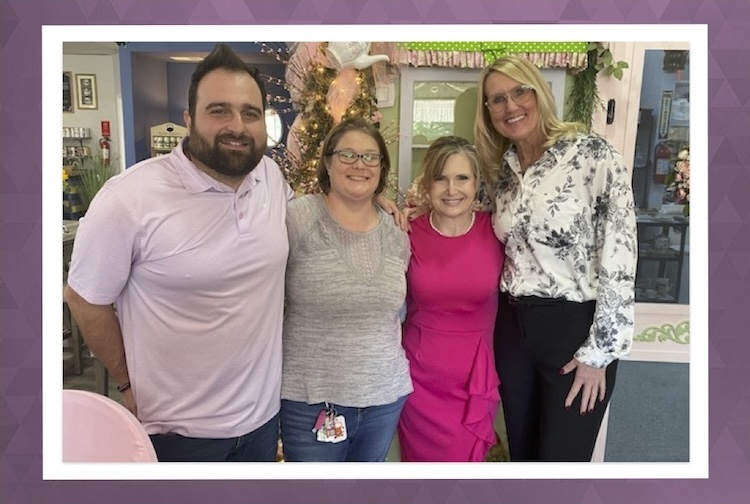 Four people standing together in a tea room