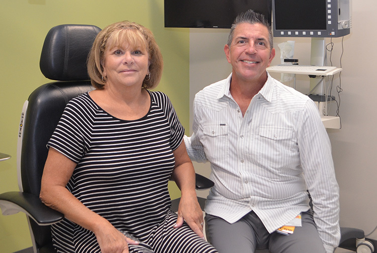 A patient and her doctor smile in an exam room.